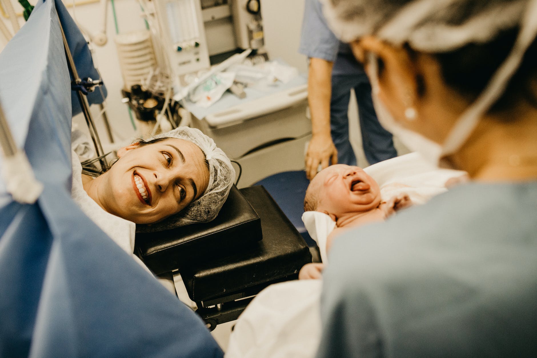 What do newborns wear at the hospital? - mother smiling looking at newborn child